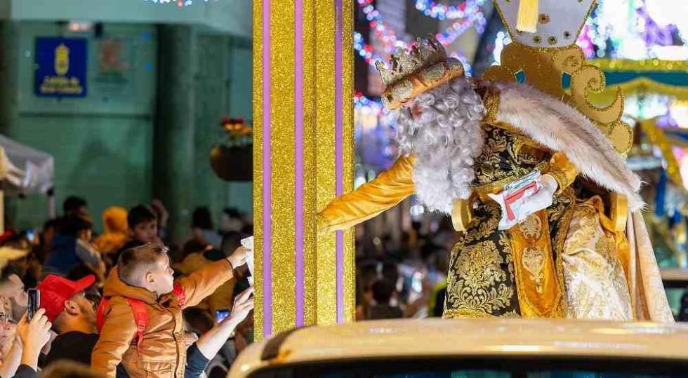 El Rey Melchor recoge la carta de un niño durante la Cabalgata en la calle Capitán Quesada