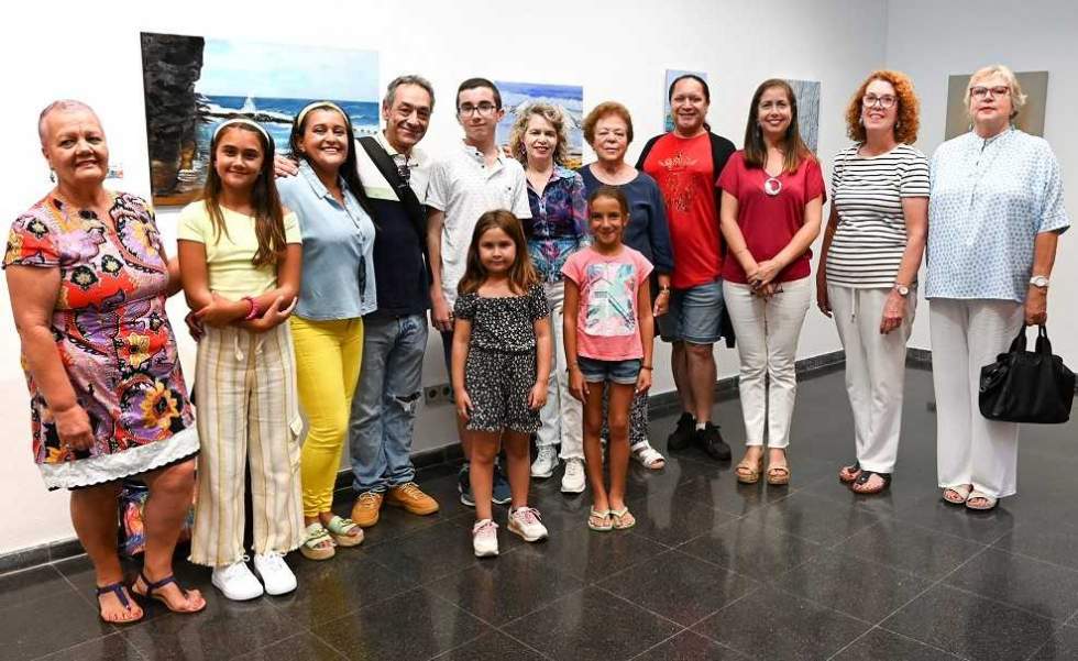 La concejala de Cultura, Sibisse Sosa, y el profesor del Aula Luján Pérez de Guía, Sergio Guerra, junto a algunos de los autores de la muestra colectiva el día de la inauguración