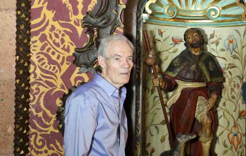 Juan Serrano Moreno, en el Camarín de la Virgen, junto a una antigua talla del compatrono San Roque en el año 2023