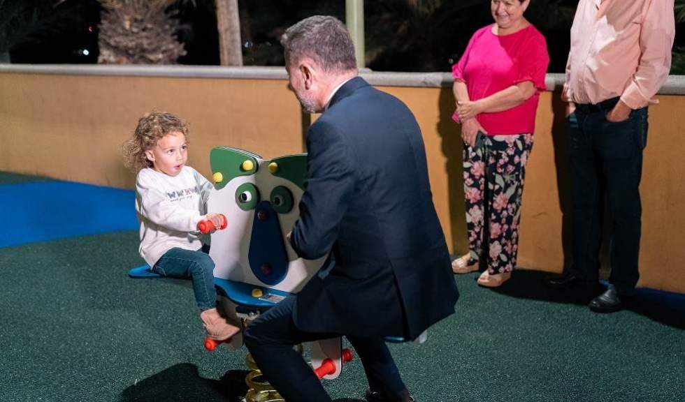 Teodoro Sosa, alcalde de la ciudad, en un balancín en el parque infantil de Tazirga junto a una niña del barrio