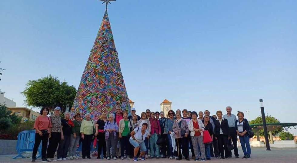 Foto de familia junto al árbol de ganchillo de la plaza de La Atalaya de los participantes en la Ruta de Belenes