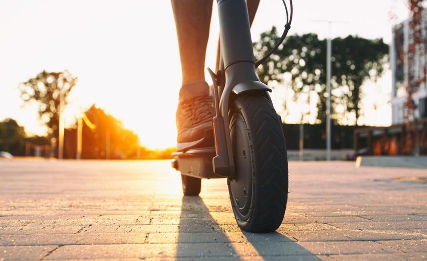 The guy riding the electric scooter in the sunset