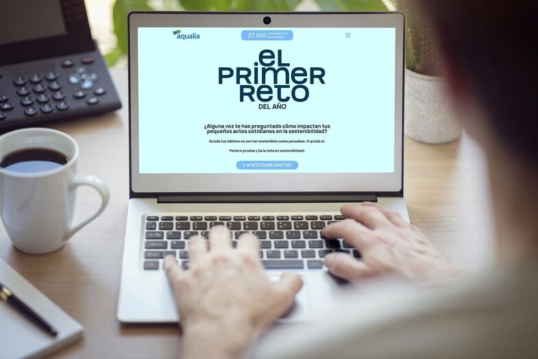 Man with laptop computer on desk working in office with blank screen