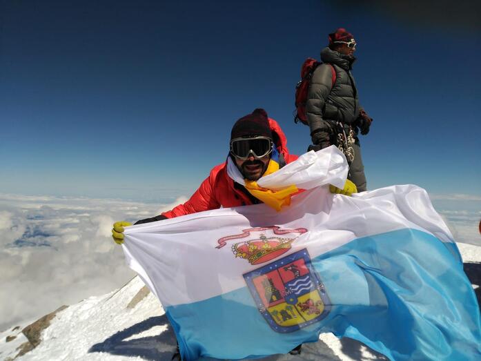 Zebensuí Díaz muestra orgulloso la bandera de Guía su Ciudad natal