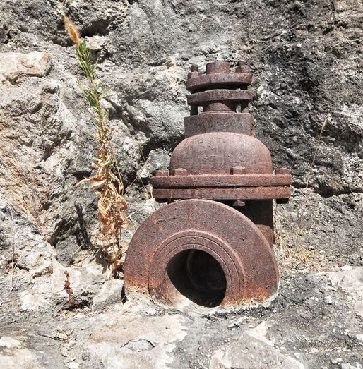 Llave antigua de pequeña presa de mampostería 