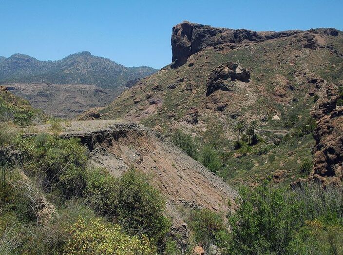 La escombrera, las palmas y la Mesa de Soria en lo alto