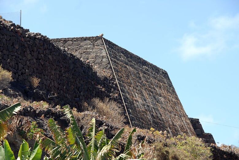 Un estanque de bellas líneas con filtraciones históricas en su pared exterior